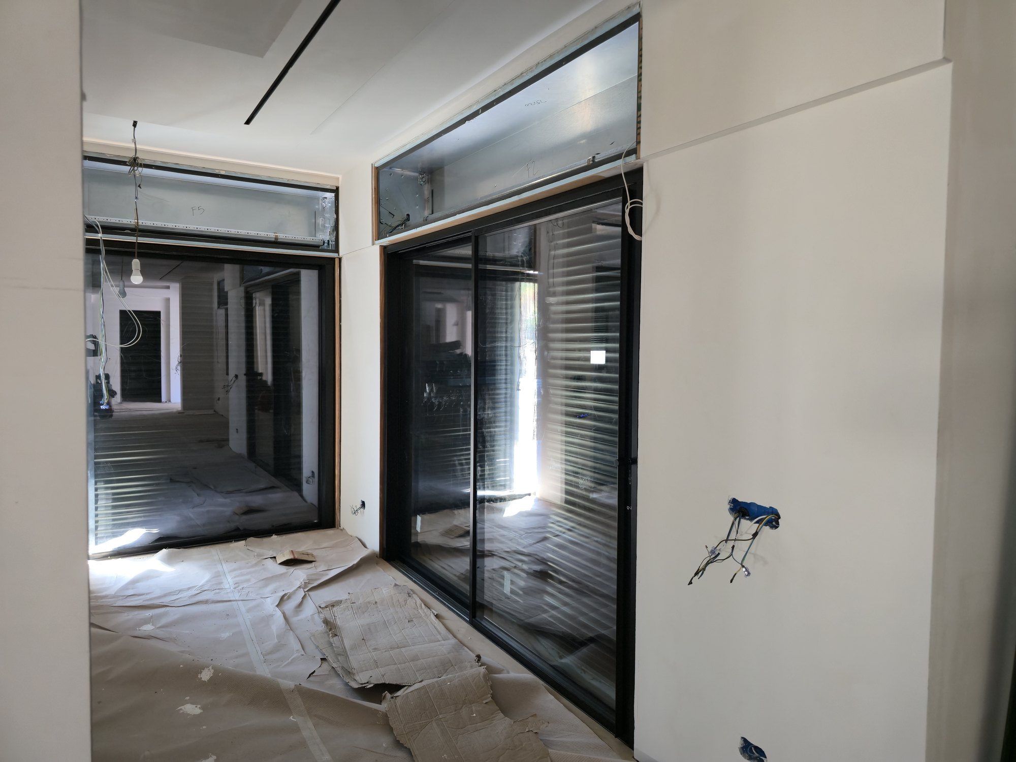 Due scorrevoli in alluminio ad angolo con i rispettivi monoblocchi: la sigla scritta sul cassonetto (F2, F5) richiama la posizione a progetto, così in cantiere ogni pezzo va al suo foro.
