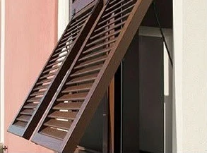 Persiana effetto legno scuro accanto a una scala esterna