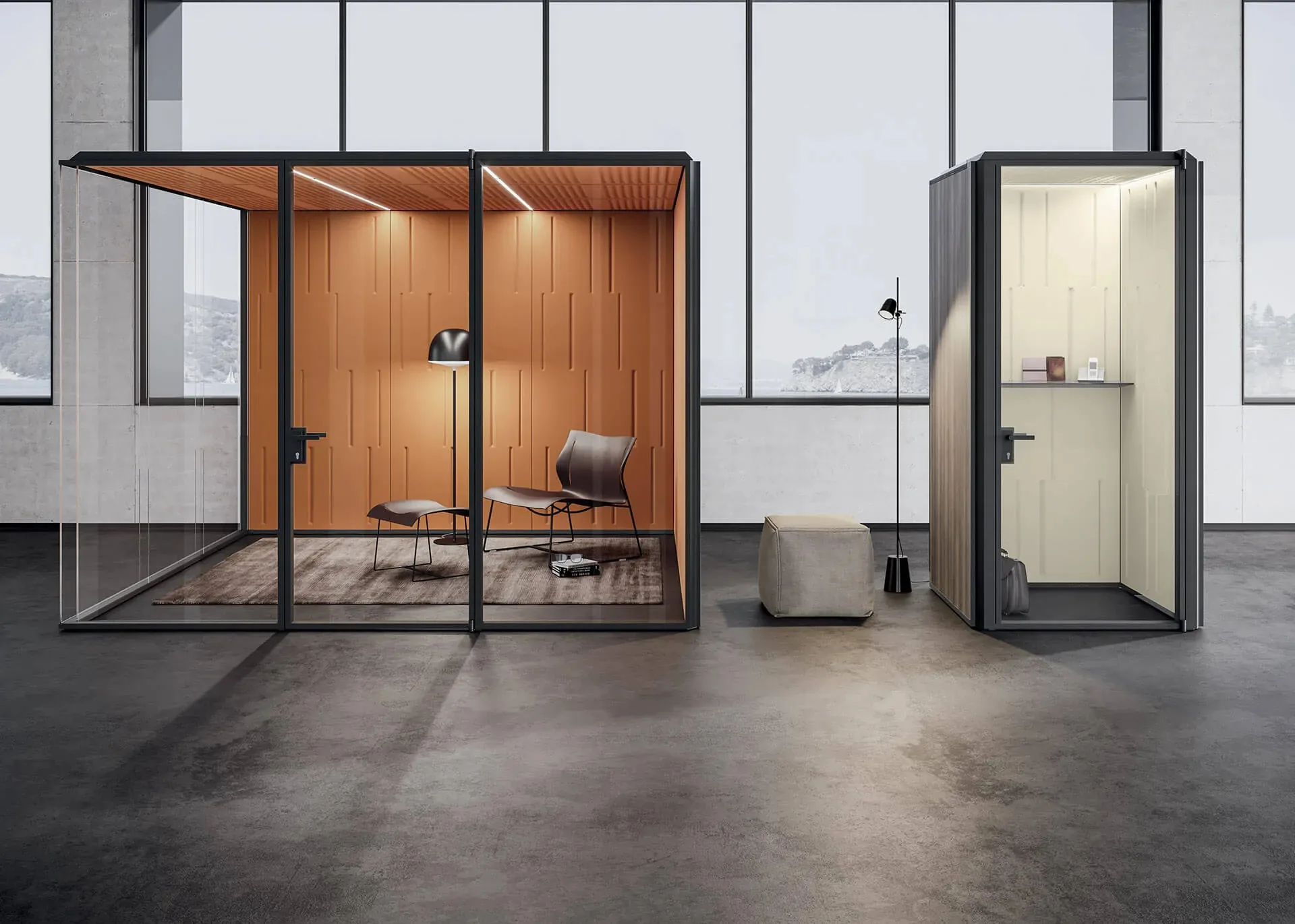 Box INBOX con pannelli acustici arancio, poltroncina e lampada da terra, accanto a una cabina singola in un loft
