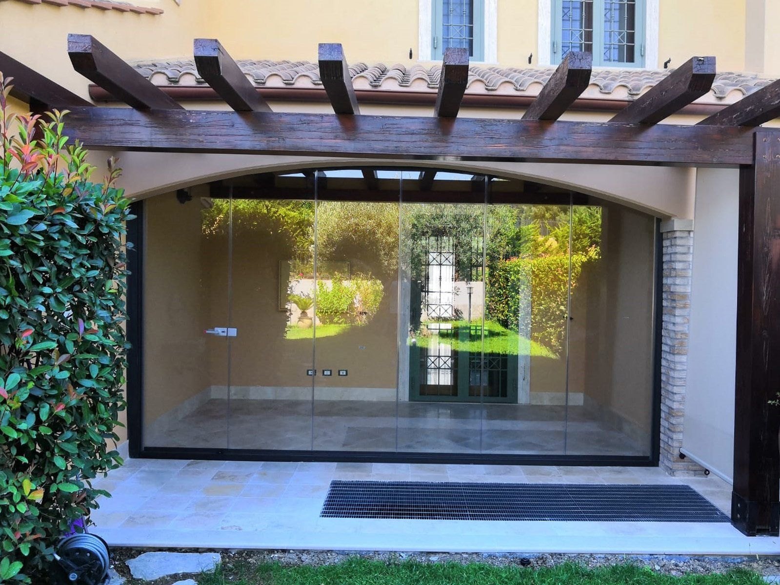 Portico di una villa chiuso da una vetrata panoramica tutto-vetro a pacchetto