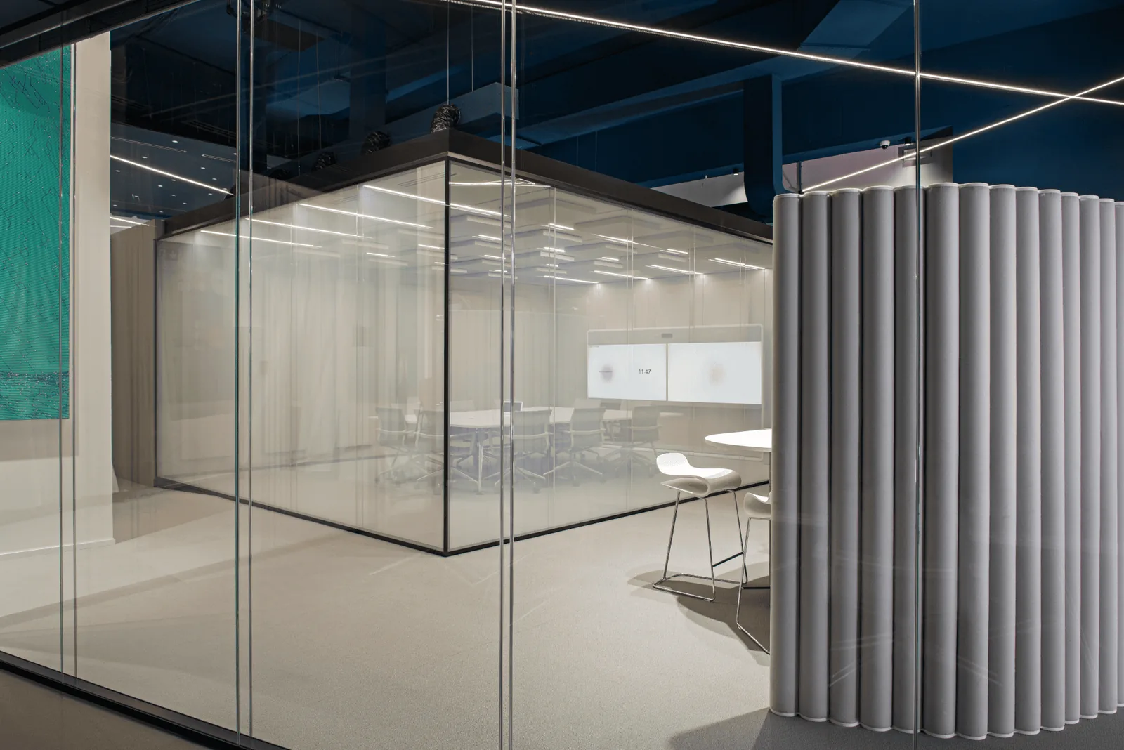 Sala riunioni col soffitto blu scuro, vista attraverso altre pareti in vetro